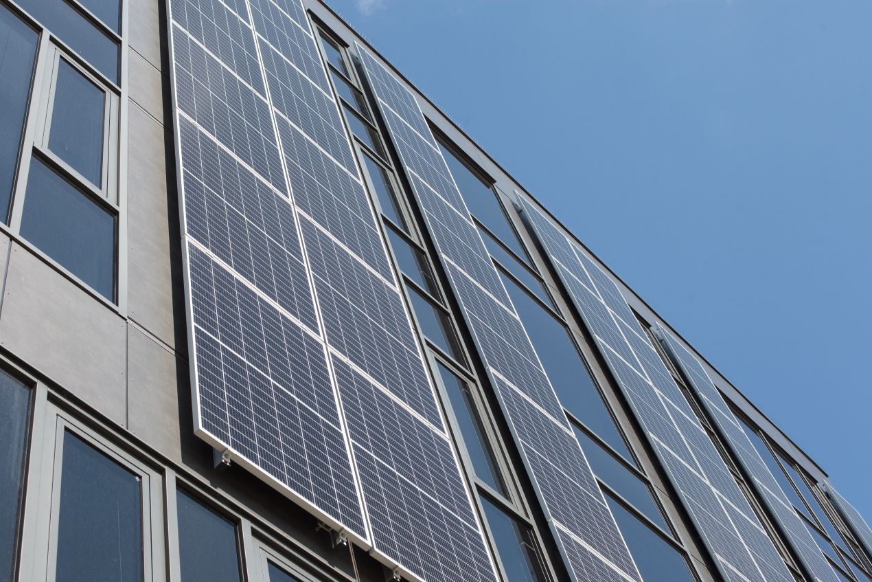 Moderne Glas Glas Photovoltaik Module an einer Gebäude-Fassade bieten eine nachhaltige und platzsparende Energiegewinnung.
