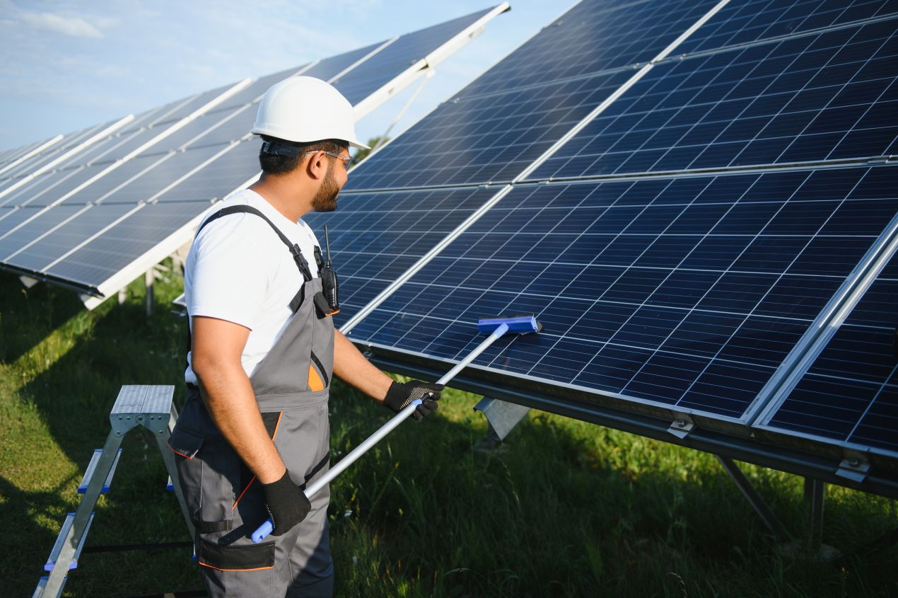 Ein Techniker reinigt Glas Glas Photovoltaik Module, um die Effizienz und den Ertrag der Solaranlage langfristig zu optimieren.